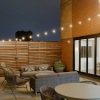 a rooftop area with a couch, chairs and a table