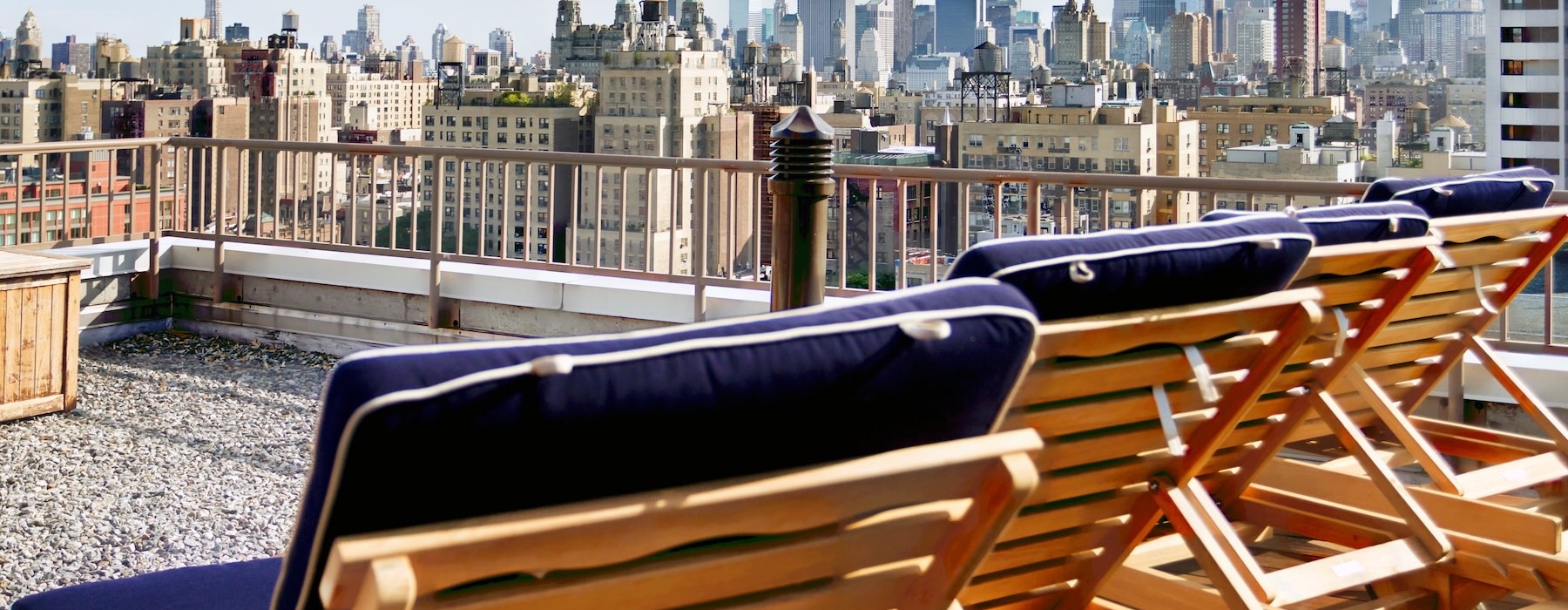 a deck with chairs and a city skyline in the background